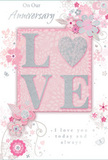 This anniversary card embodies a gentle celebration of enduring romance, set against a background of soft pastel pinks and muted silvery greys that feels as tranquil as an early evening walk through Chingford's tree-lined streets. At the centre, the word LOVE is spelled out in softly rounded, raised glitter letters, with the letter O beautifully replaced by a shimmering heart. The heart is textured in silver, slightly more reflective than the surrounding blush-pink glitter, creating a subtle focal point that immediately draws the eye. The raised design suggests a tactile pleasure, similar to tracing the curve of a flower stem or the edge of a petal. Encircling this central motif, delicate blossoms in blush, mauve and ivory unfurl with an almost watercolour softness. The petals are outlined with fine, flowing lines, some accented with hints of silver, giving the impression of a hand-illustrated bouquet composed with a florist's precision. Light vines and tendrils weave in and out of the flowers, while tiny flourishes-scattered petals, graceful swirls and small, understated butterflies-add motion and whimsy, reminiscent of an English spring garden after a light breeze. Above or near the central design, the phrase On Our Anniversary is written in an elegant, slightly slanted script, with I love you today and always appearing below in matching, understated lettering. The typography echoes the curves of the vines, tying text and illustration into a single harmonious design. Overall, the card feels both intimate and refined, the sort of keepsake often tucked alongside an anniversary bouquet ordered for same-day delivery across Chingford, capturing a shared journey that is soft-spoken yet deeply heartfelt.